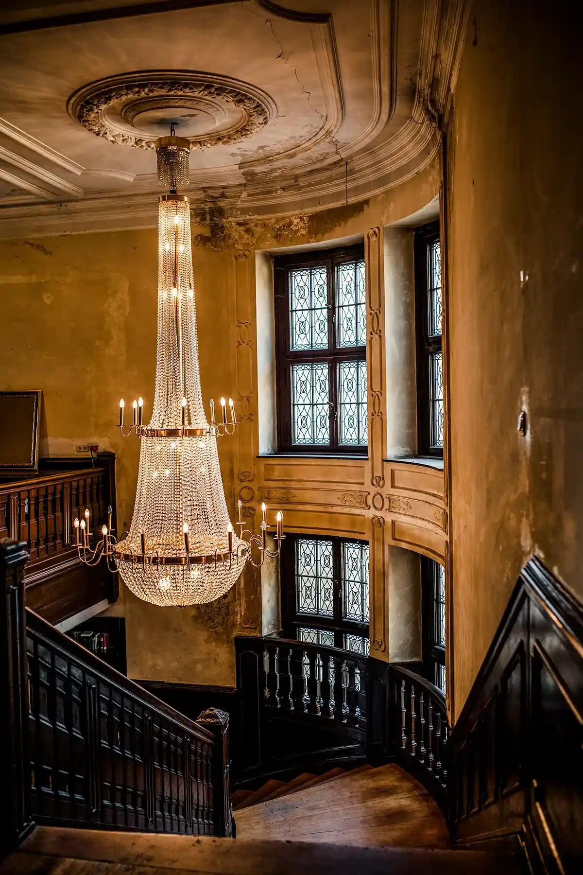 Historischer Innenraum mit Kamin und hohen Fenstern
