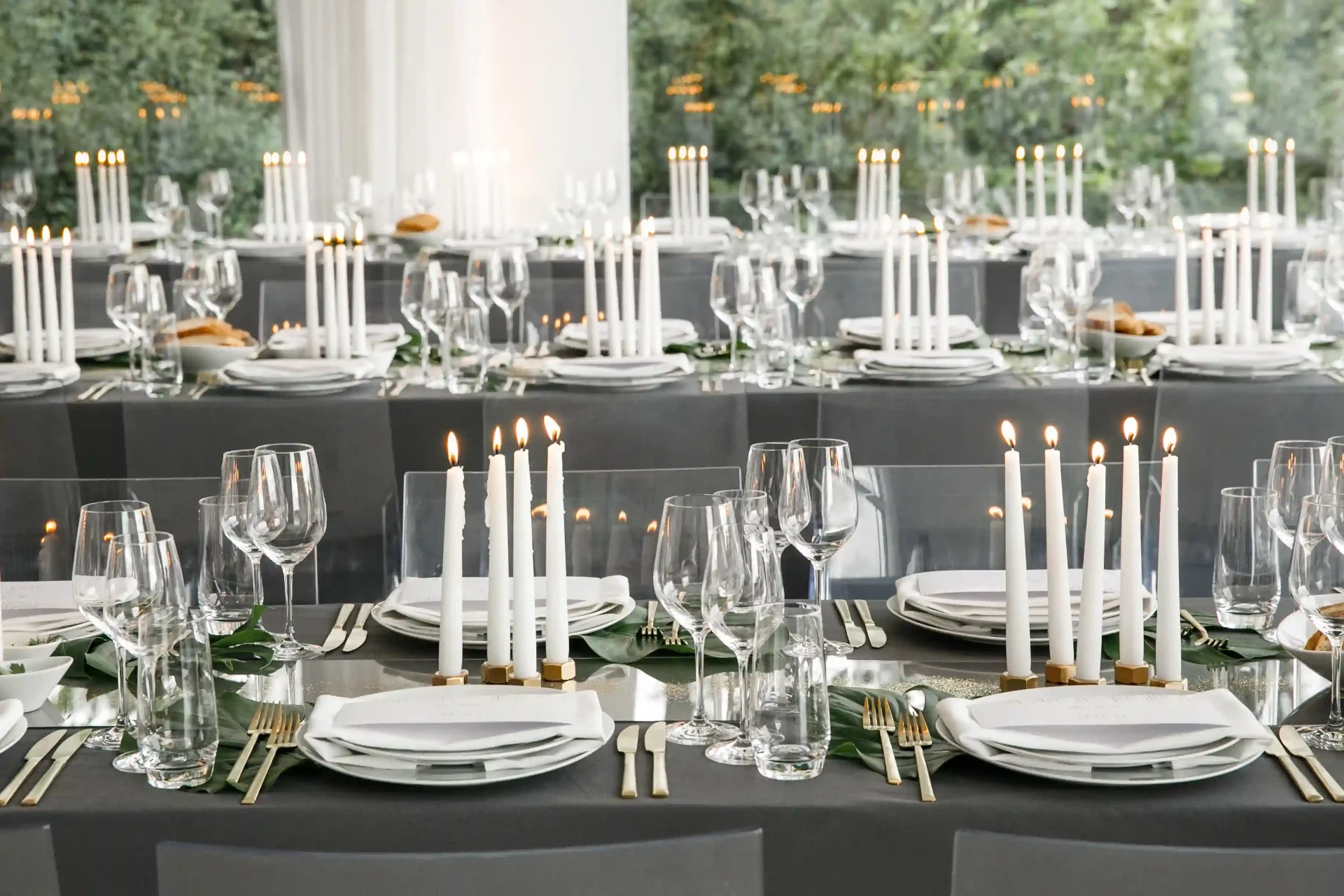 Lange Tafel im Freien mit weißen Tischdecken und Blumendekoration