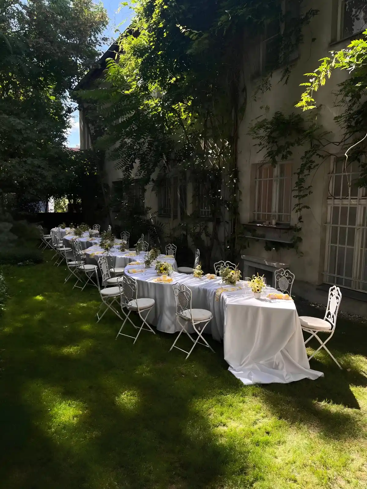 Weiße Dinner-Tafel im Freien zwischen Bäumen