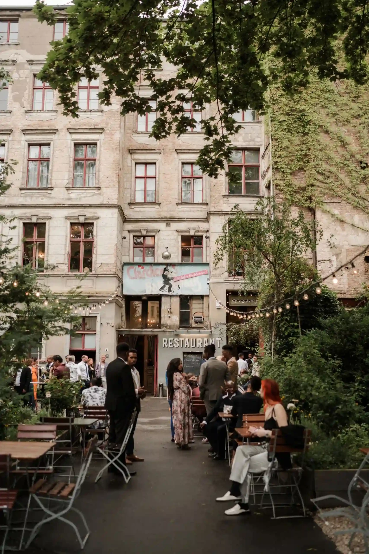 Street café with tables and chairs in front of a Berlin apartment building