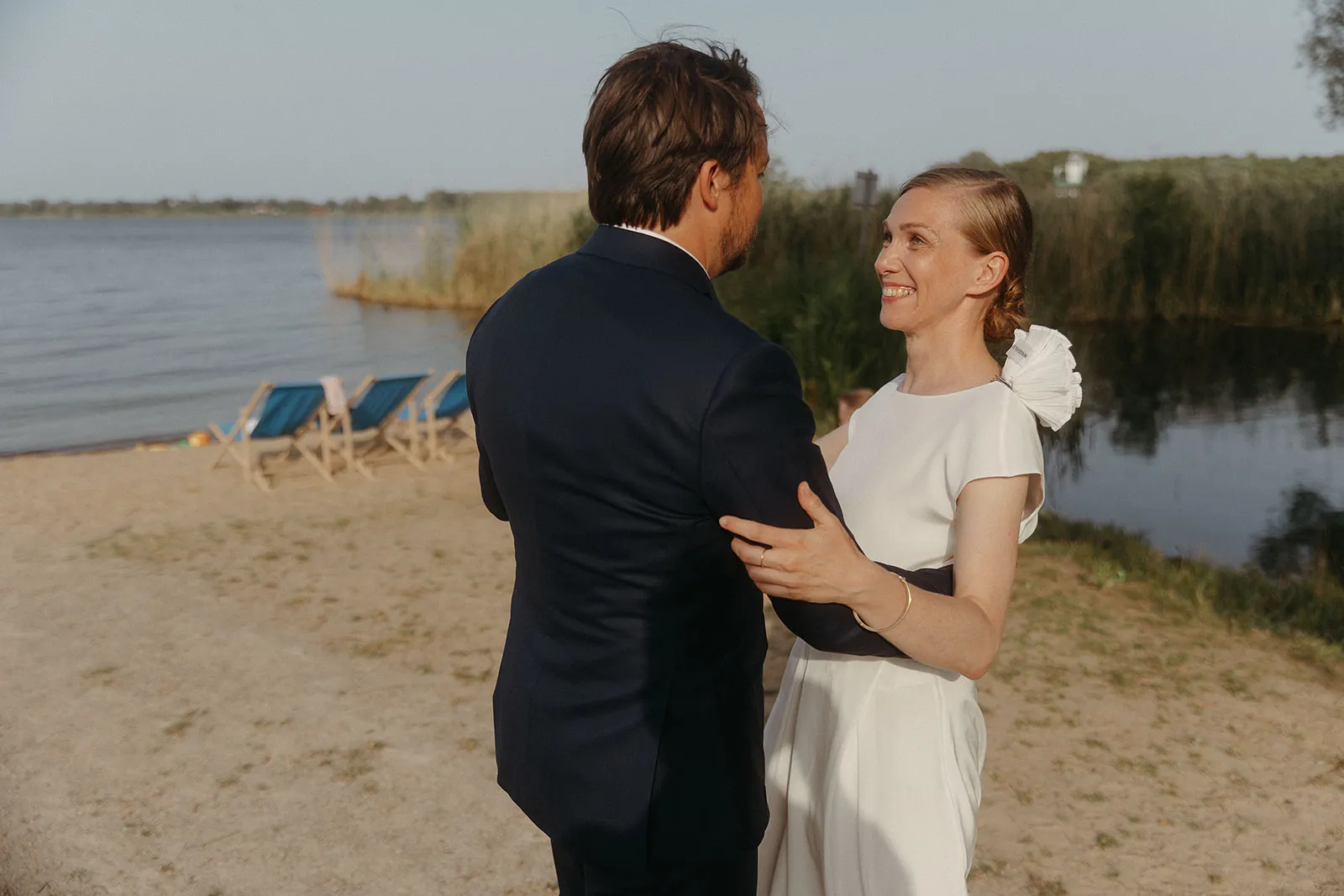 Bride and groom laughing together on the beach