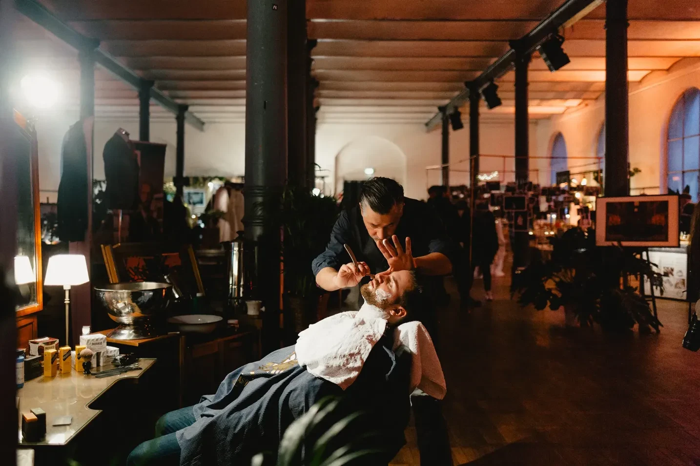 Hairstylist styling a person in a dark room