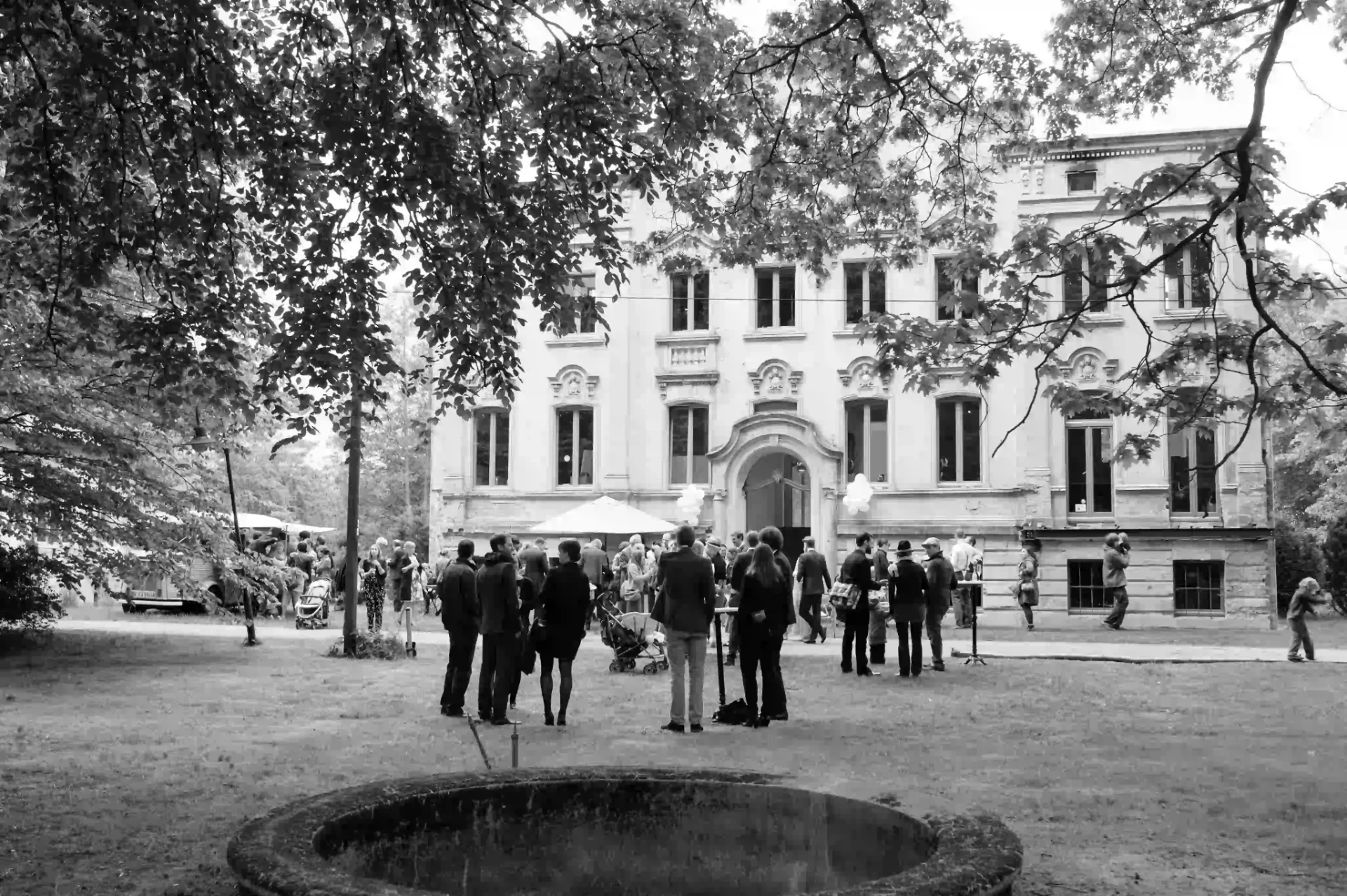 Black-and-white photograph of wedding guests outside a historic building