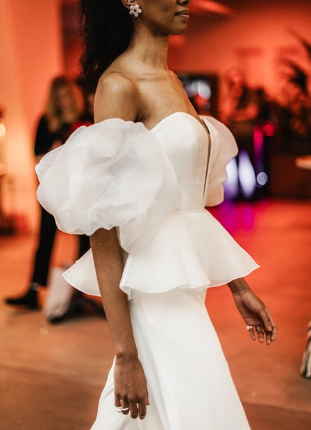 Woman in a white dress dancing in a room lit in red