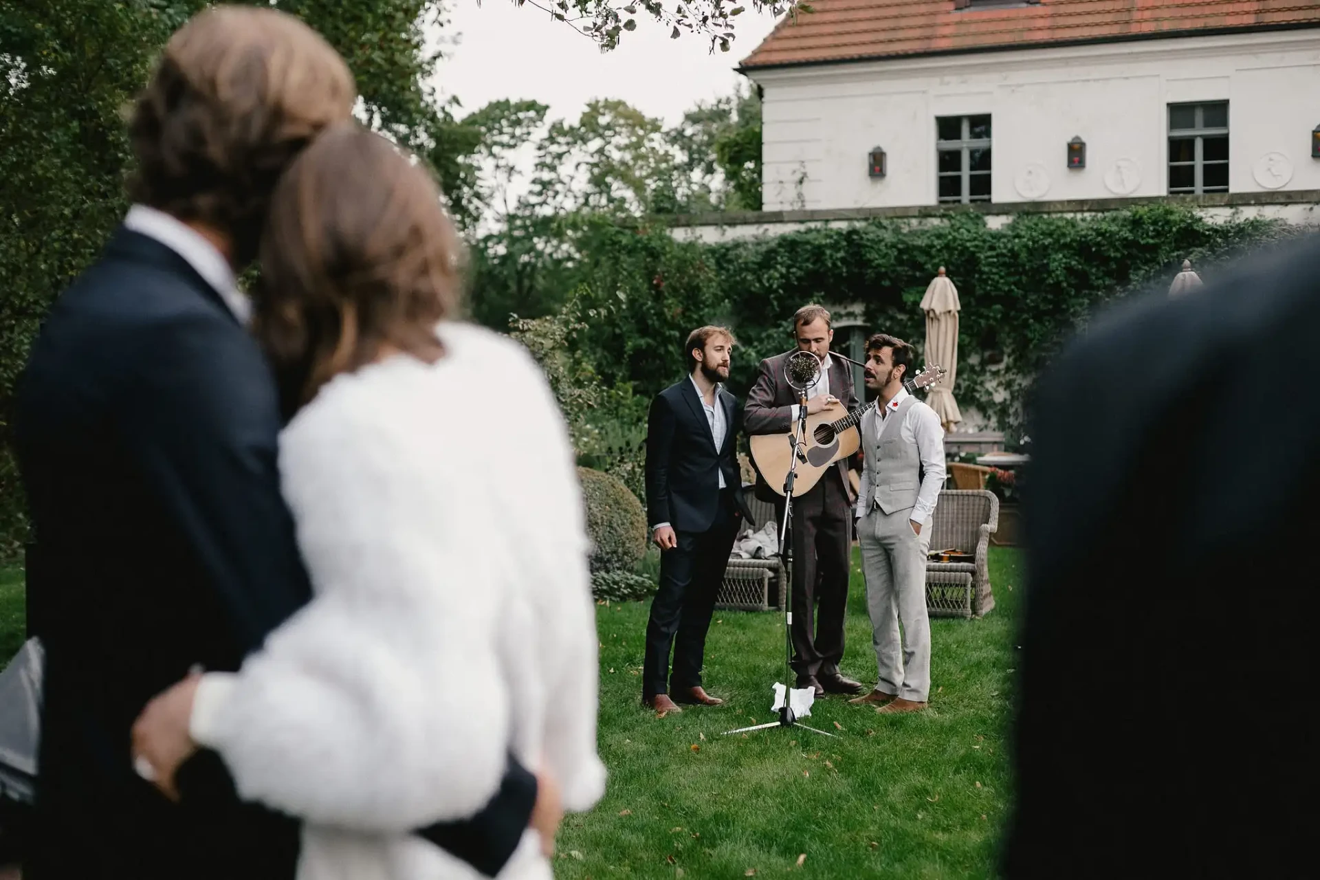 Wedding couple being greeted by guests in the garden