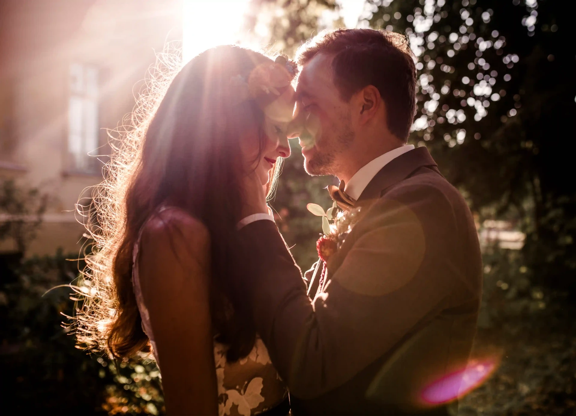 Bride and groom embracing in a sunlit garden