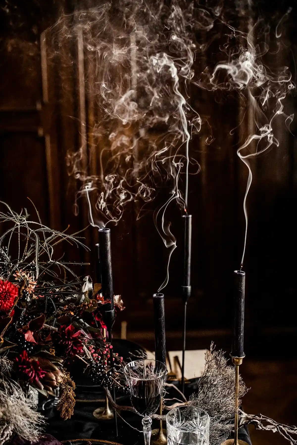 Hängende florale Installation mit dunklen Zweigen und Blüten