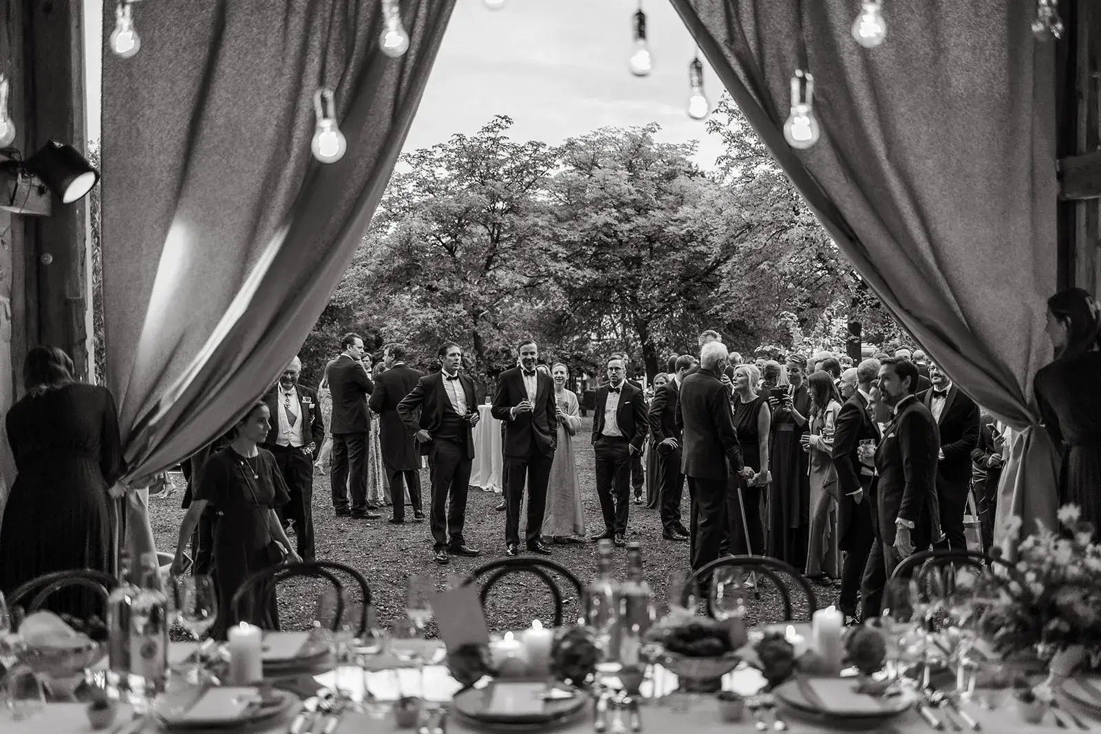 Wedding guests gathered outside a reception tent