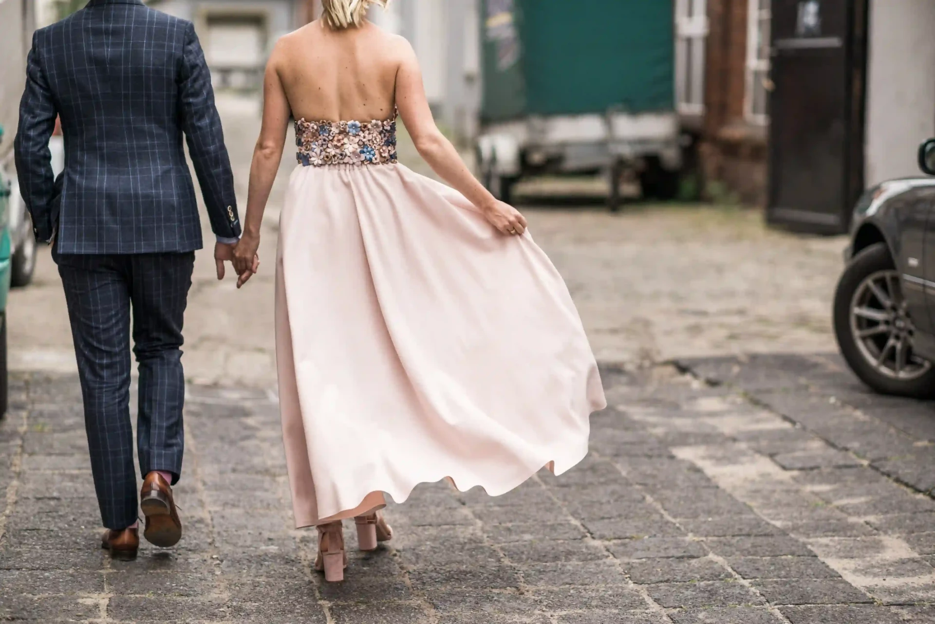 Wedding couple walking hand in hand along a cobbled street