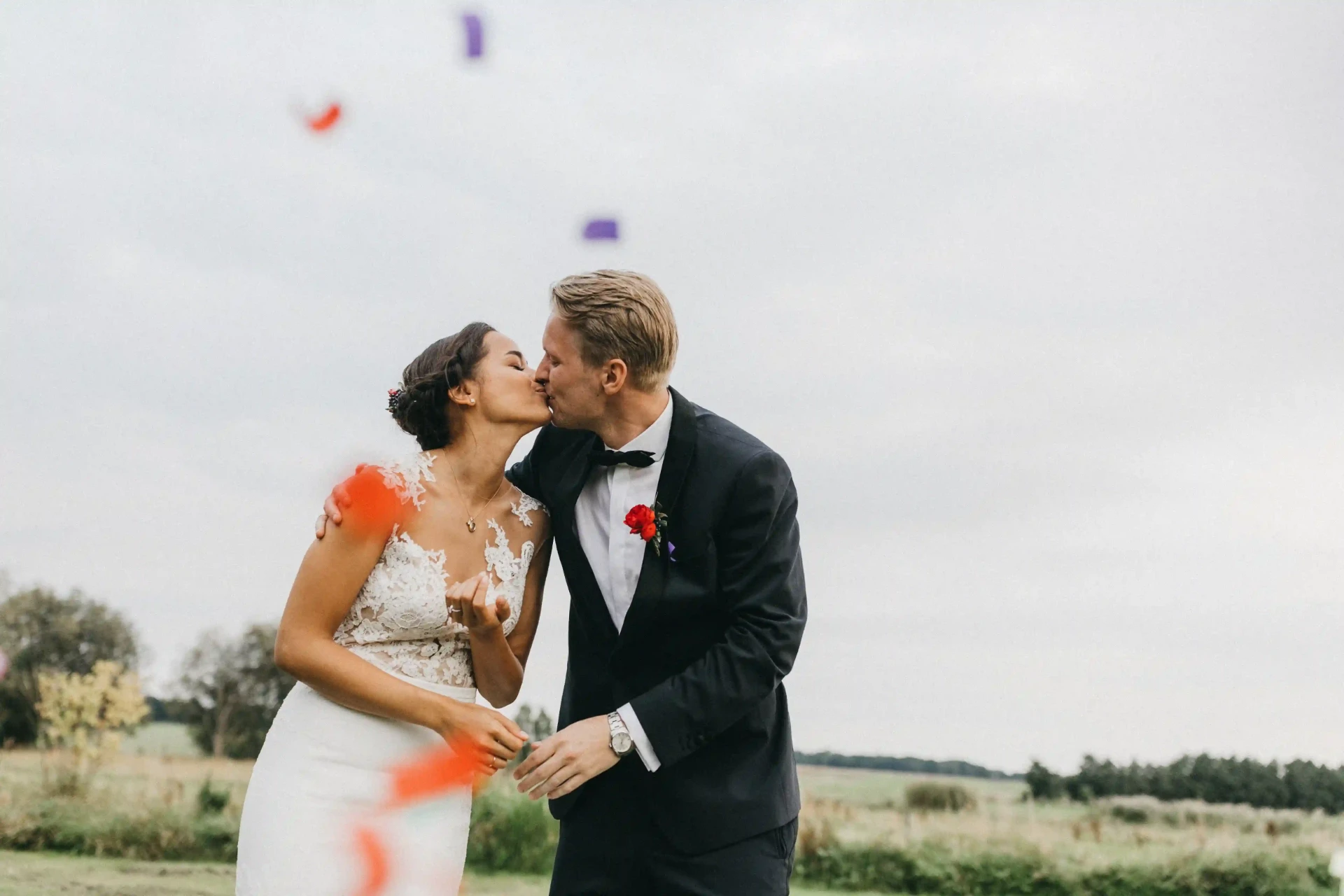 Bride and groom standing in a meadow before the ceremony