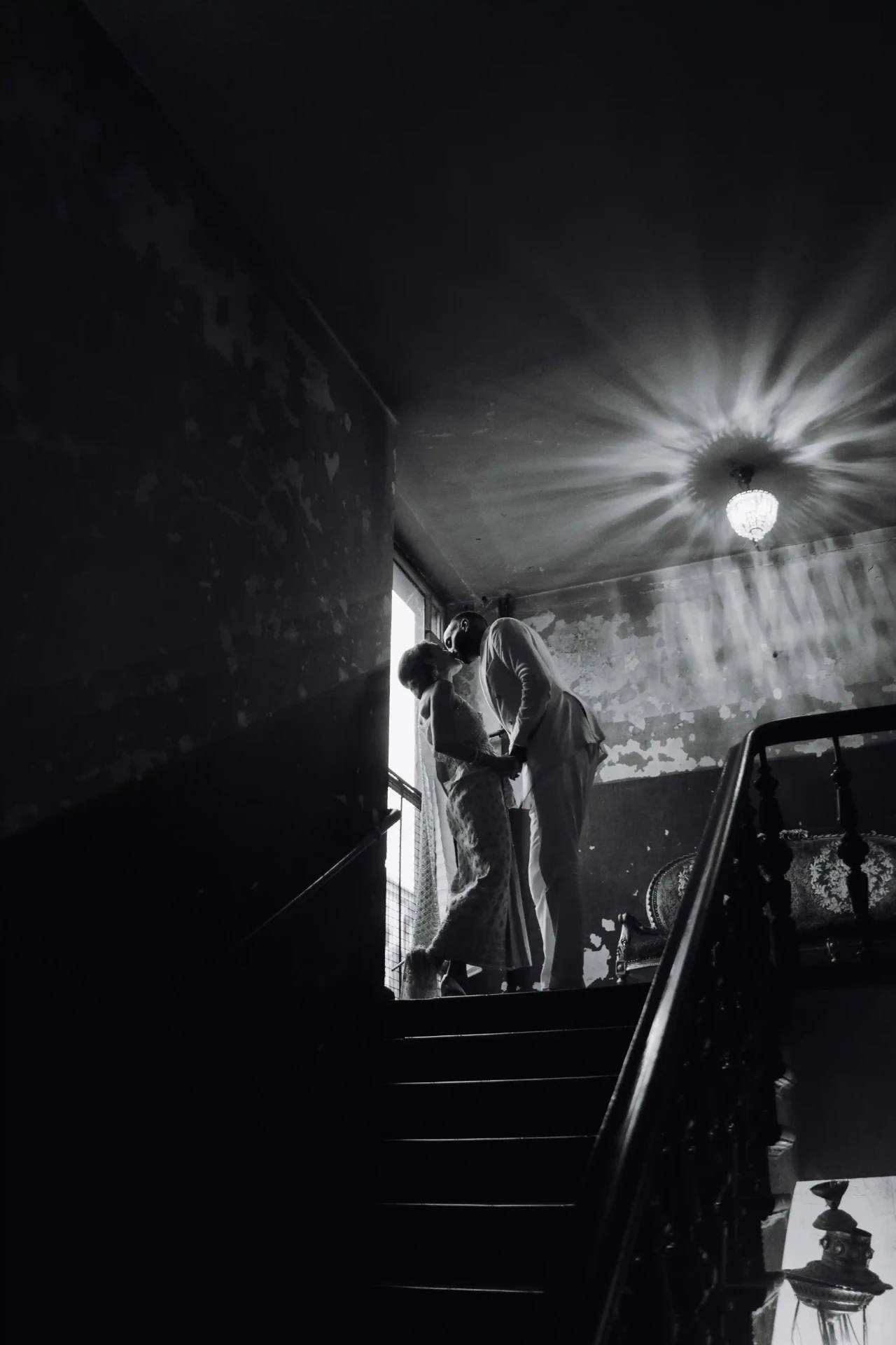 Black-and-white photograph of an illuminated staircase in a historic building