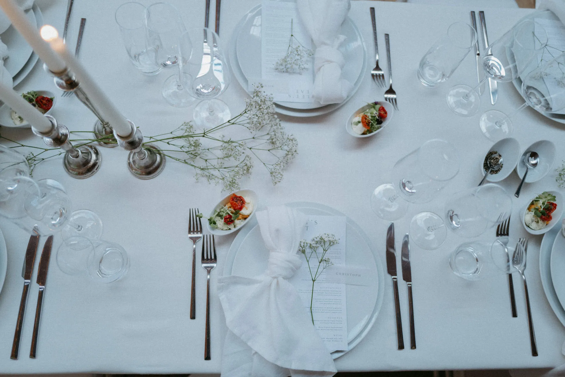 Wedding table beneath a high barn roof with hanging flowers