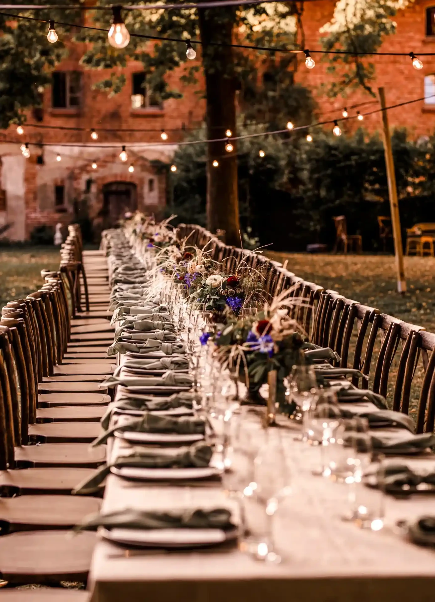 Long wedding table with white chairs in the castle garden