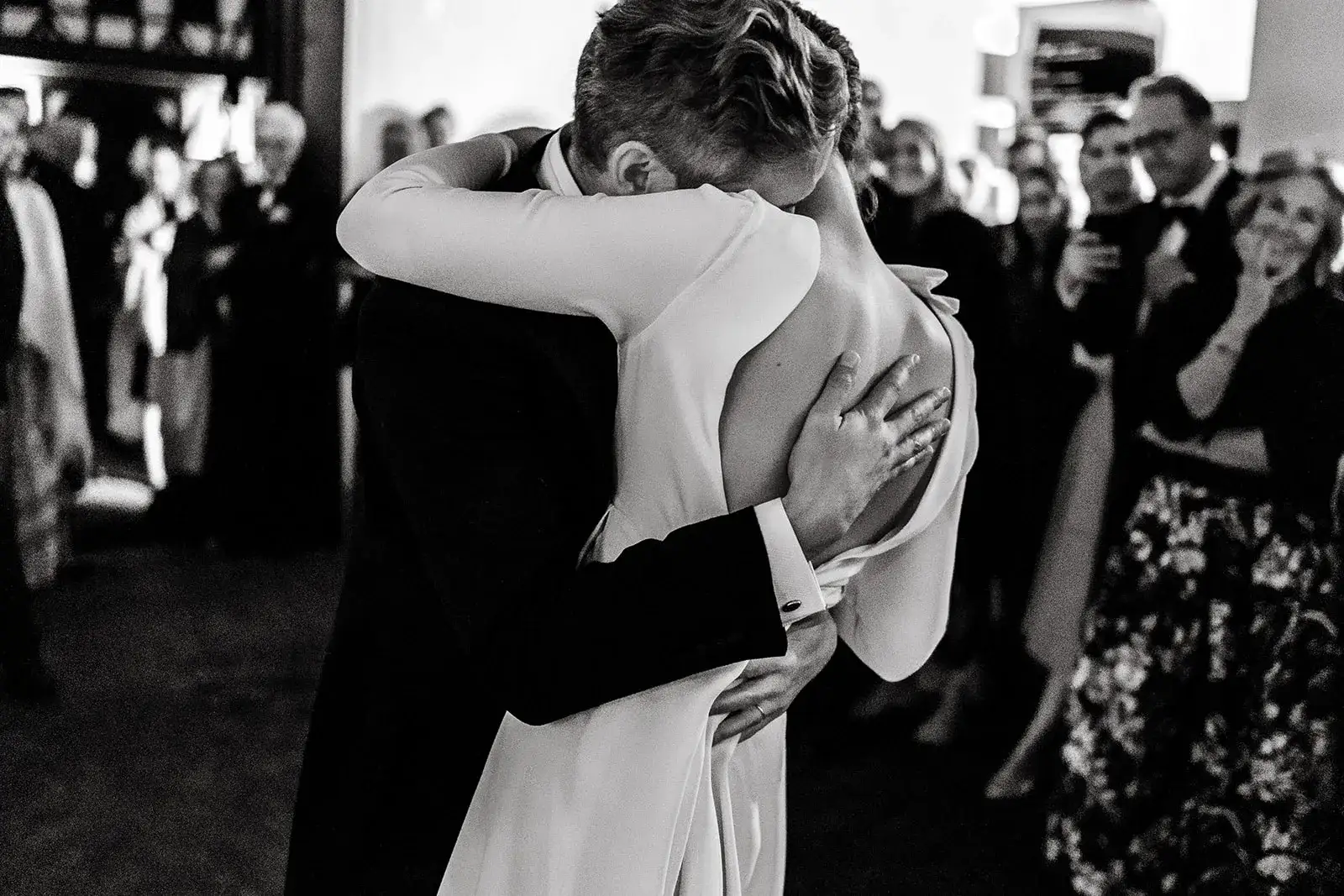 Wedding couple embracing on the dance floor among their guests