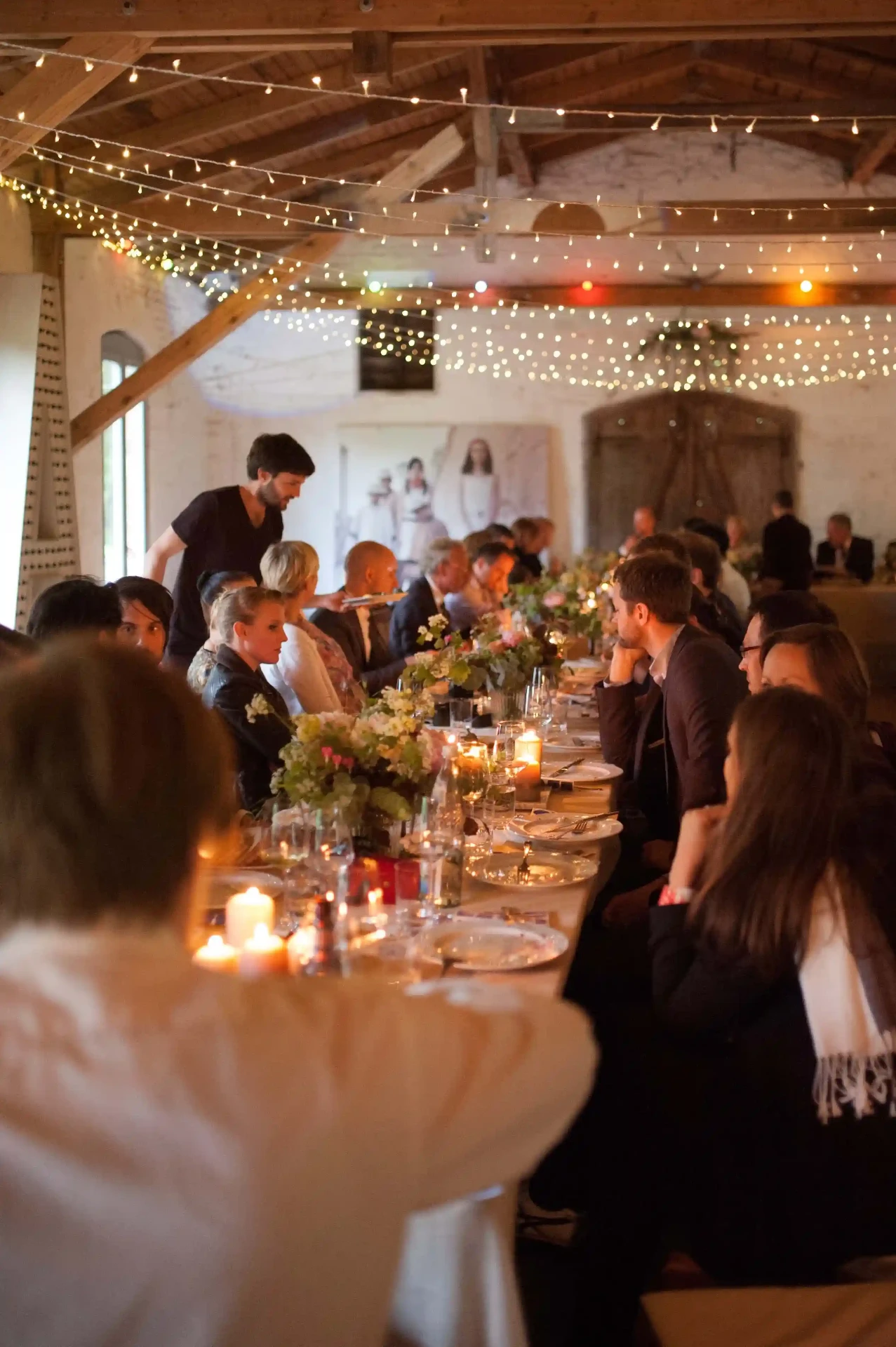 Guests having dinner in a rustic barn