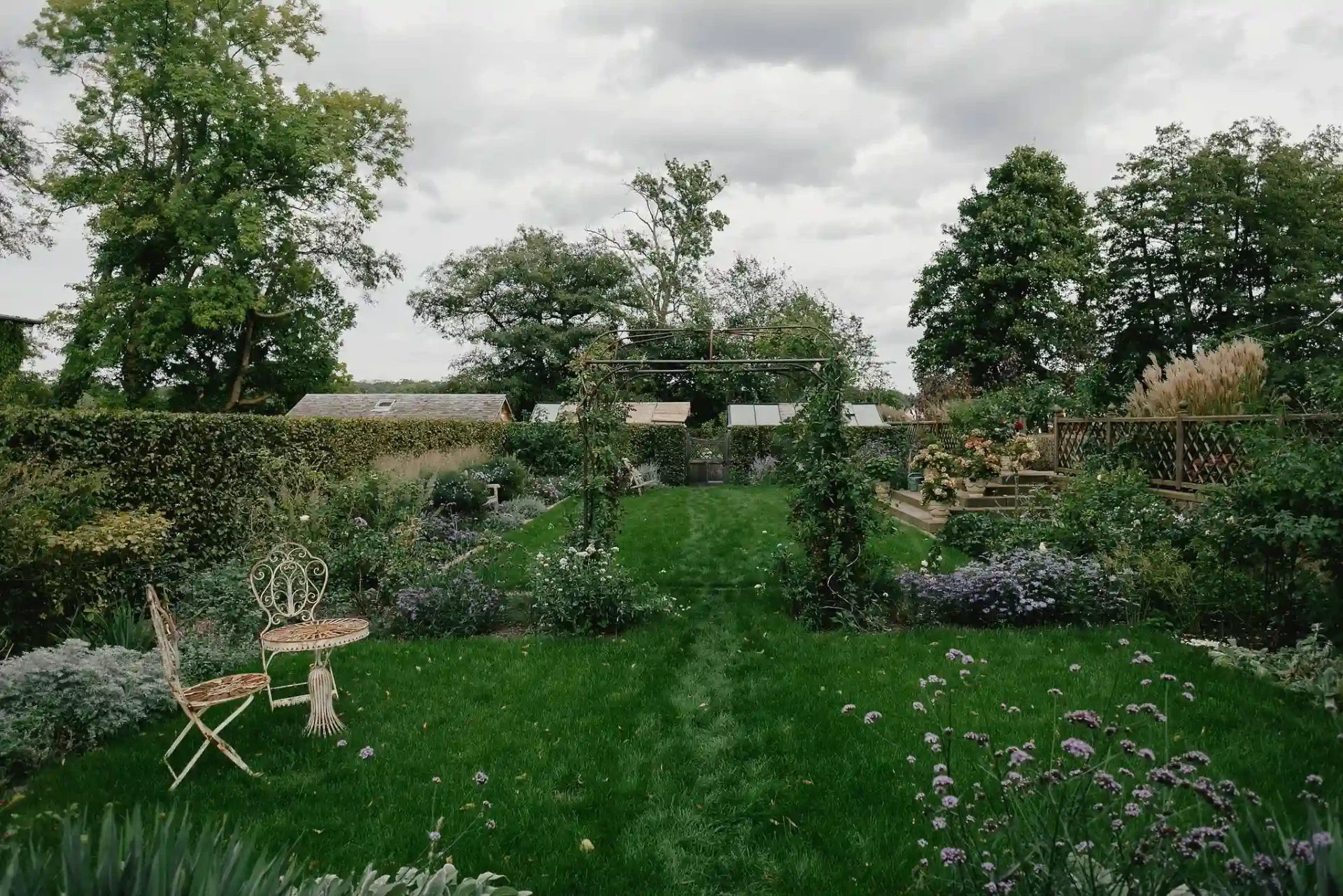 Garden beside a lake with chairs and a view of the water