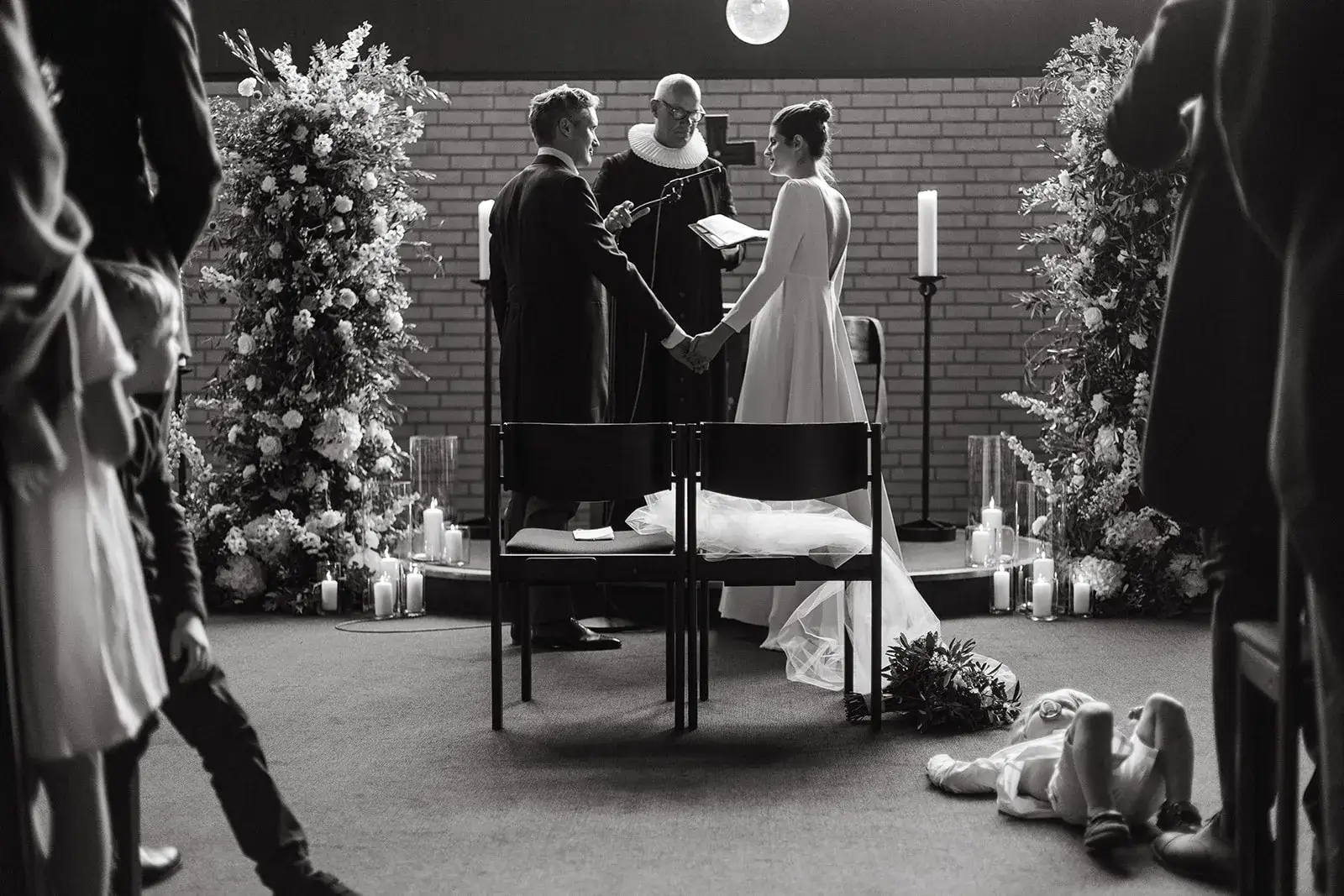 Black-and-white photograph of a wedding ceremony with guests and musicians