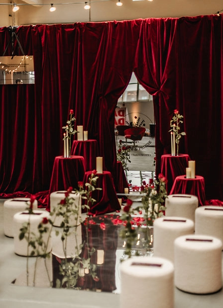 Festively set tables in front of a dark curtain
