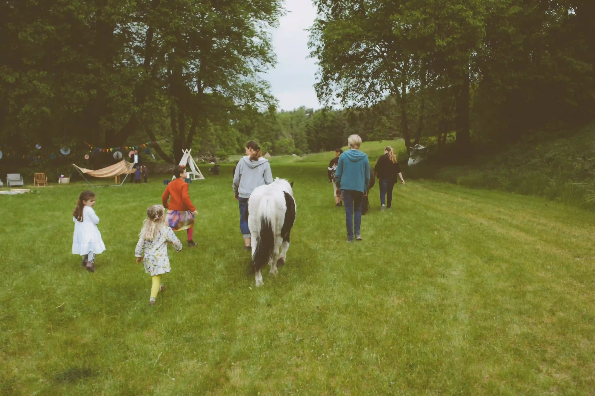 Wedding guests walking across a large green lawn