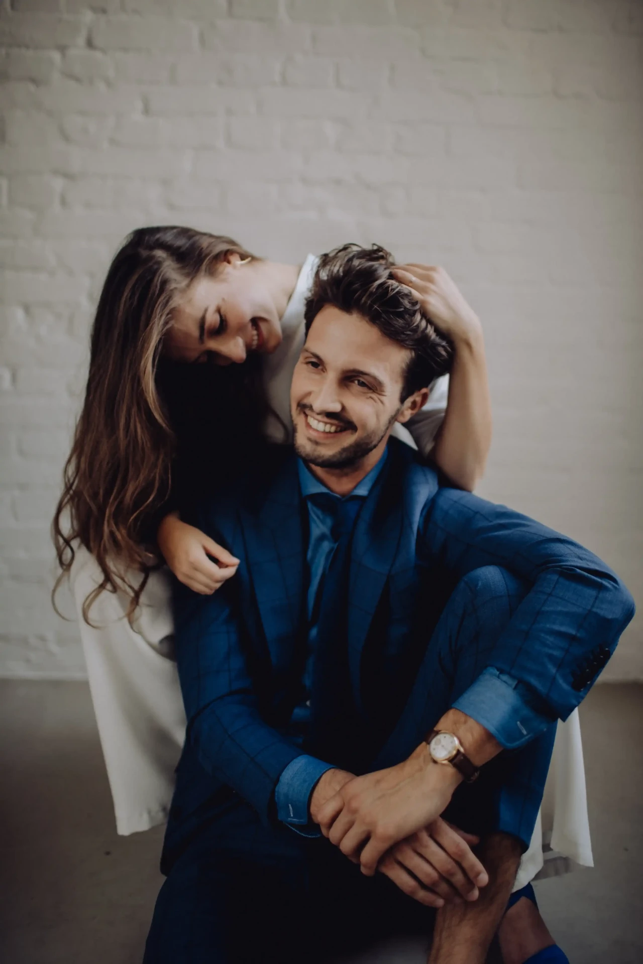 Wedding couple embracing against a light background