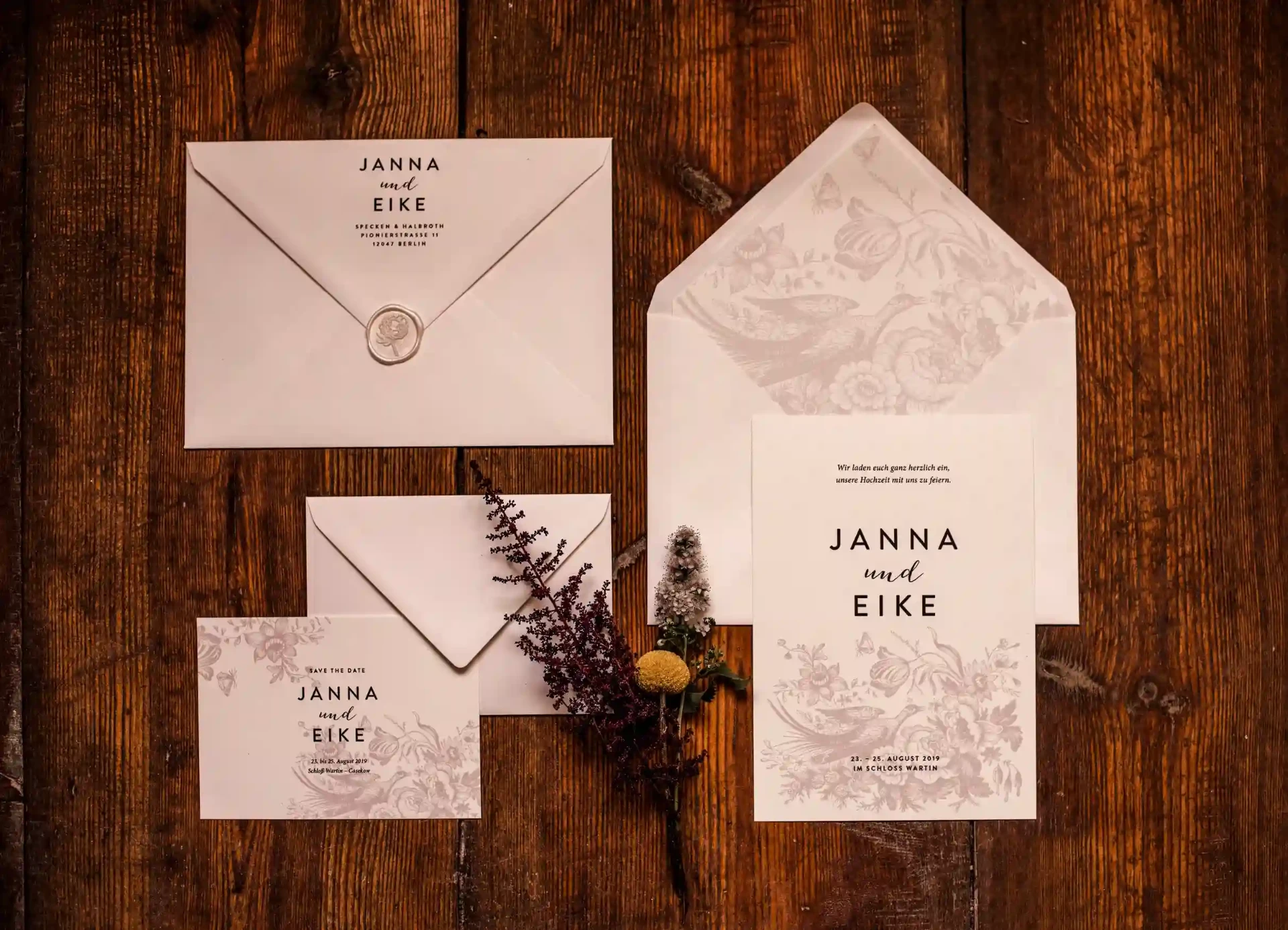 Wedding stationery with invitation cards and place cards on a wooden table