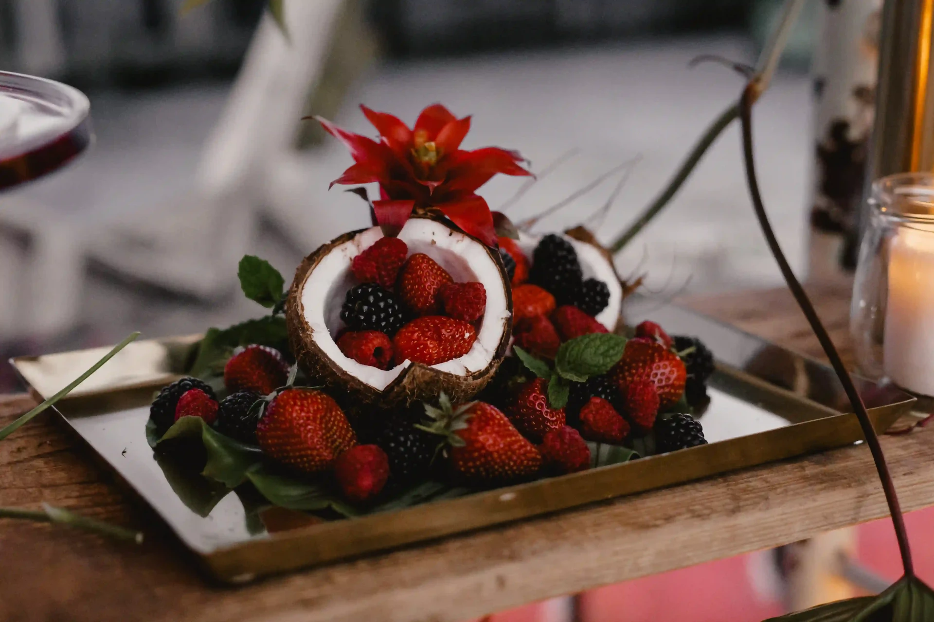Dessertarrangement mit roten Früchten und dekorativen Blüten