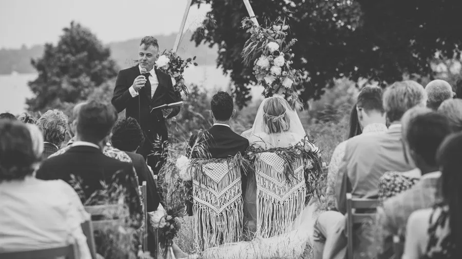 Wedding guests at an outdoor ceremony, in black and white