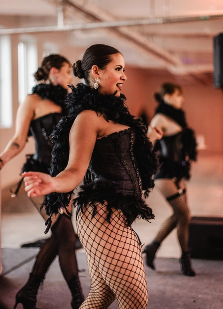 Dancers in black outfits and fishnet tights during a performance