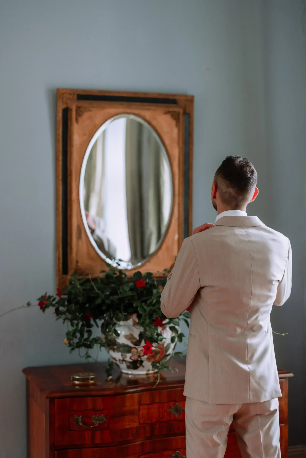 Groom looking at himself in a mirror