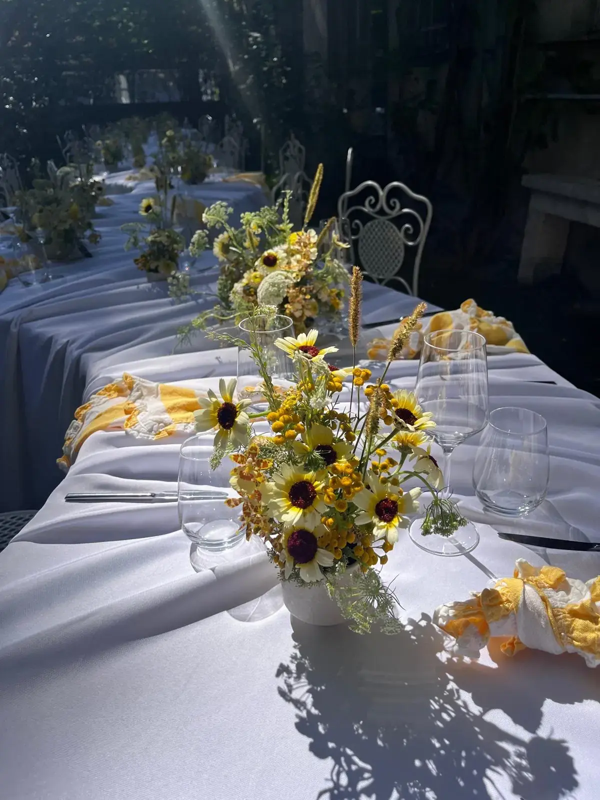 Gedeckte Tafel im Freien mit Blumen und Kerzen