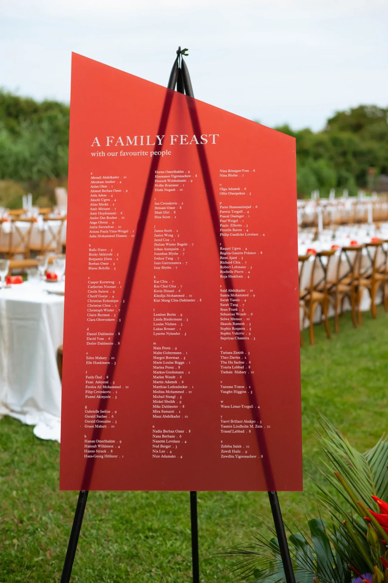 Red menu sign on a long outdoor wedding table