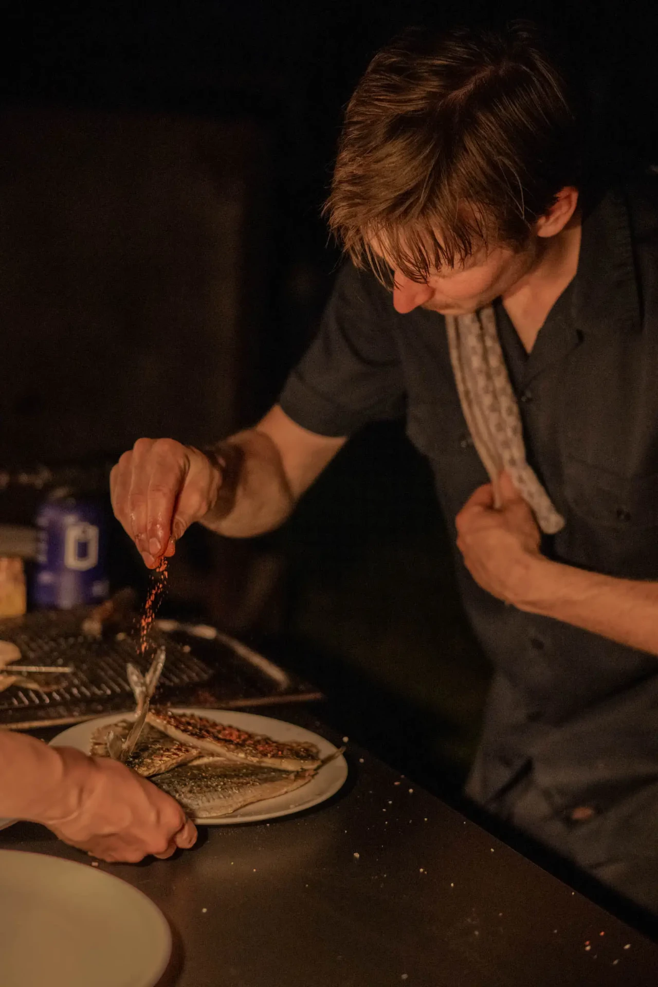 Chef preparing a dish by candlelight