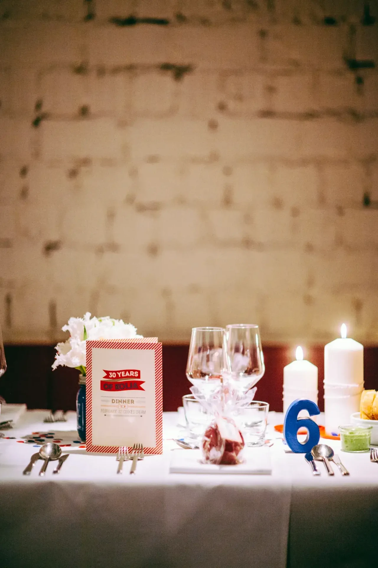 Birthday decorations and place cards in front of a brick wall