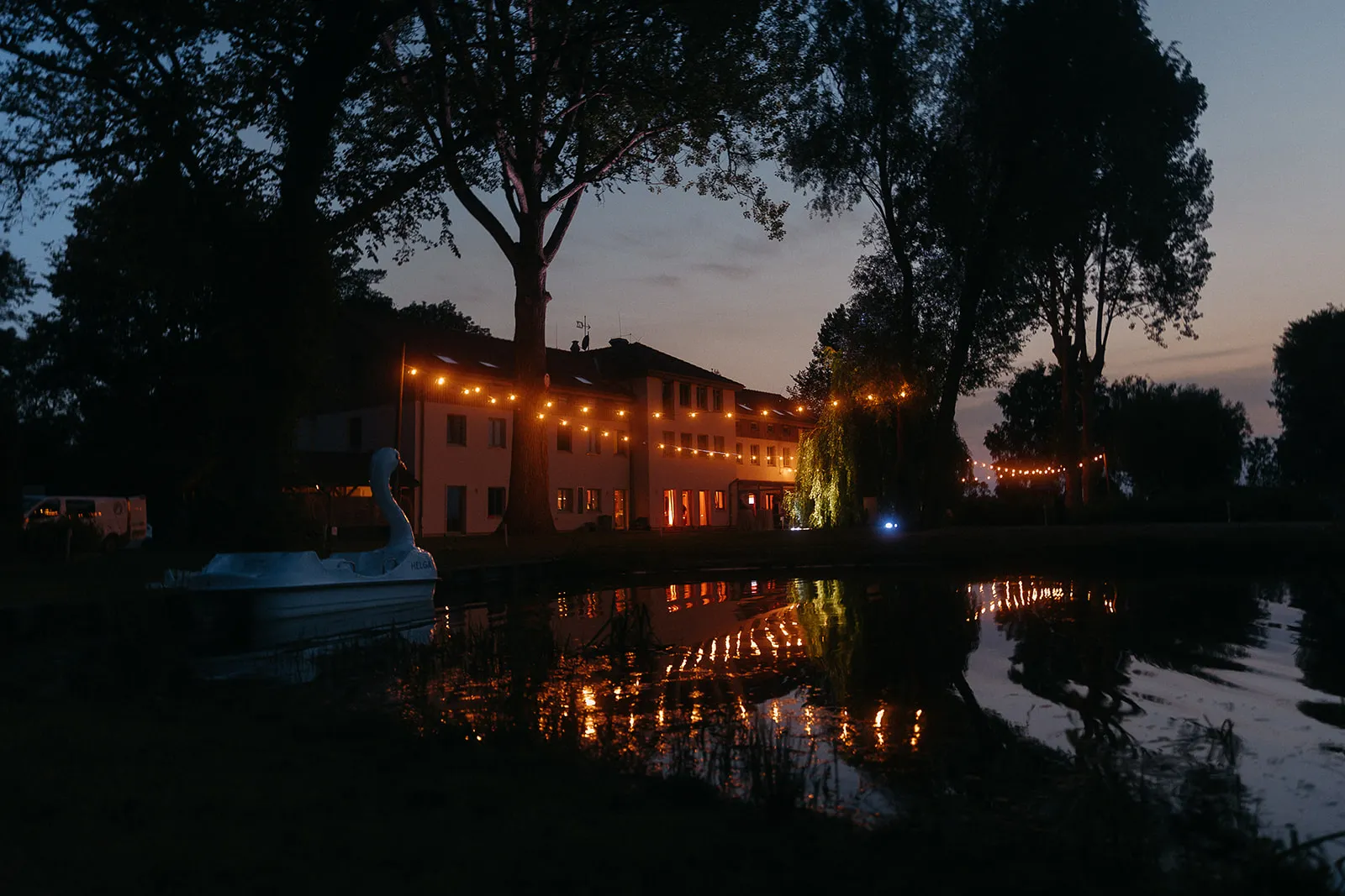 Illuminated building beside the water at night