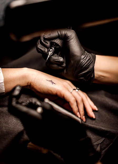 Close-up of two hands wearing jewellery against a dark background