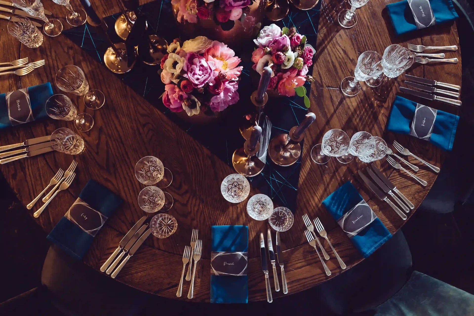 Runde Tischdekoration mit Geschirr, Blumen und Details für ein Dinner