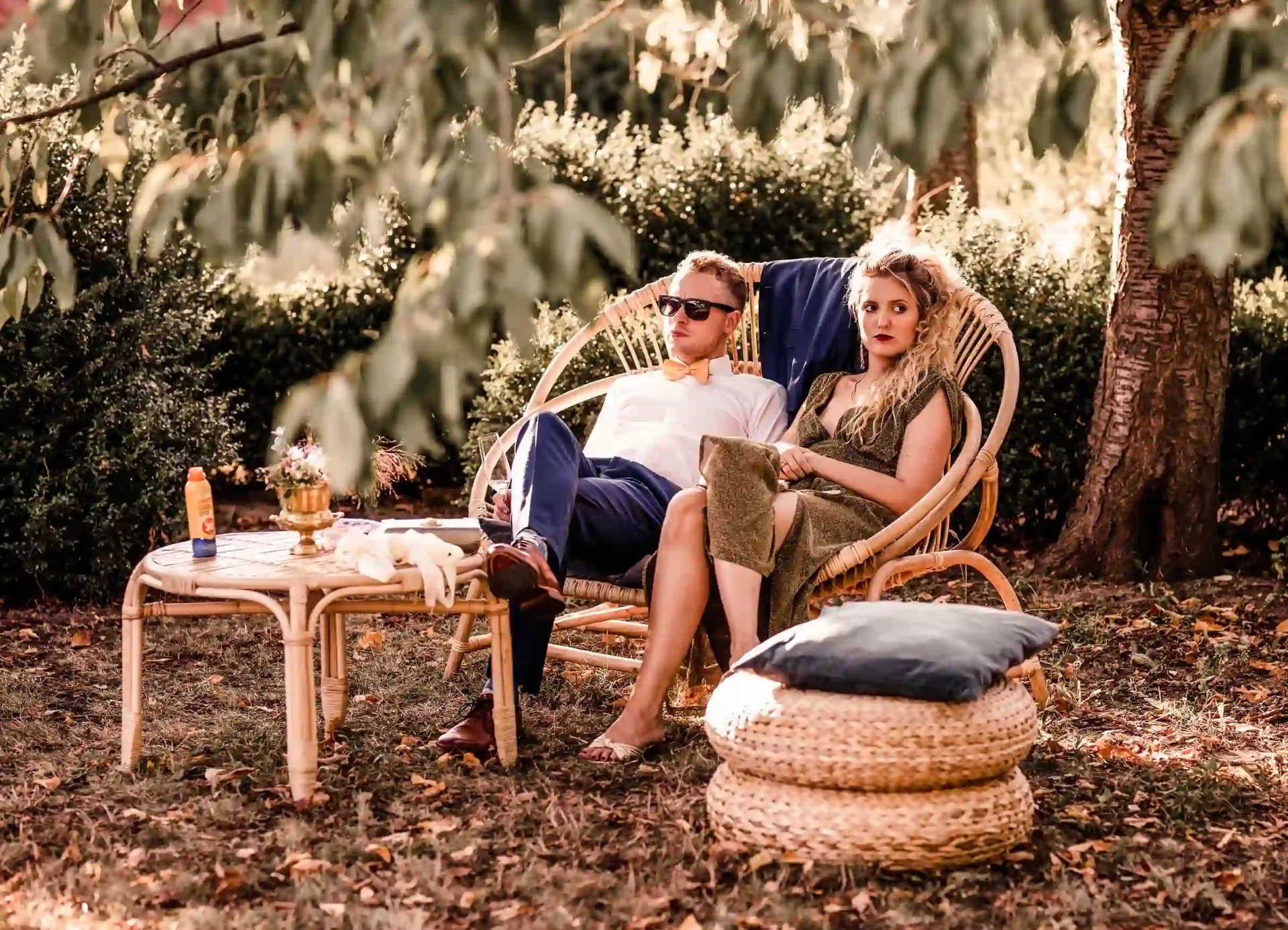 Bride and groom sitting on a garden lounge among plants