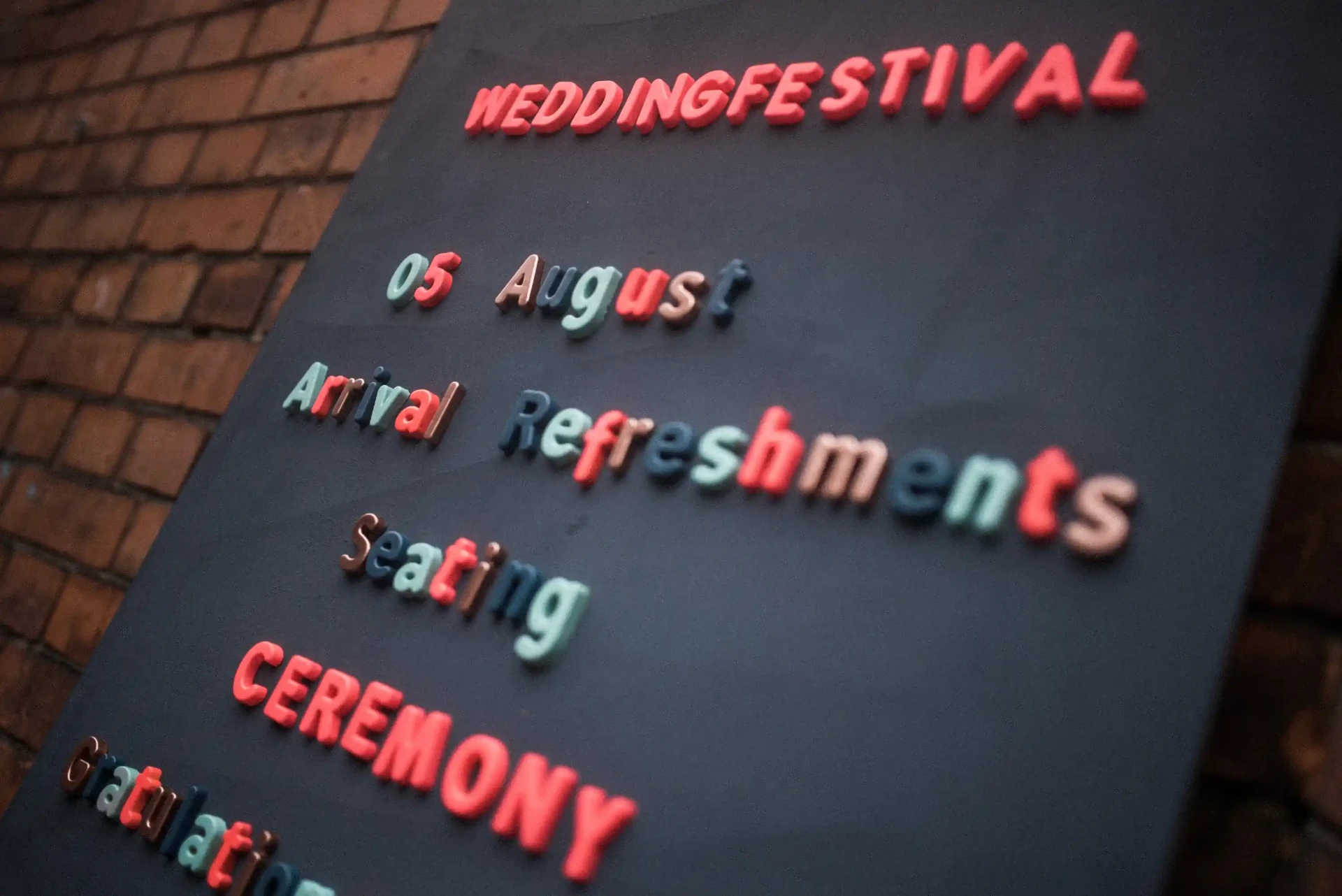 Black sign with colourful lettering for refreshments and ceremony