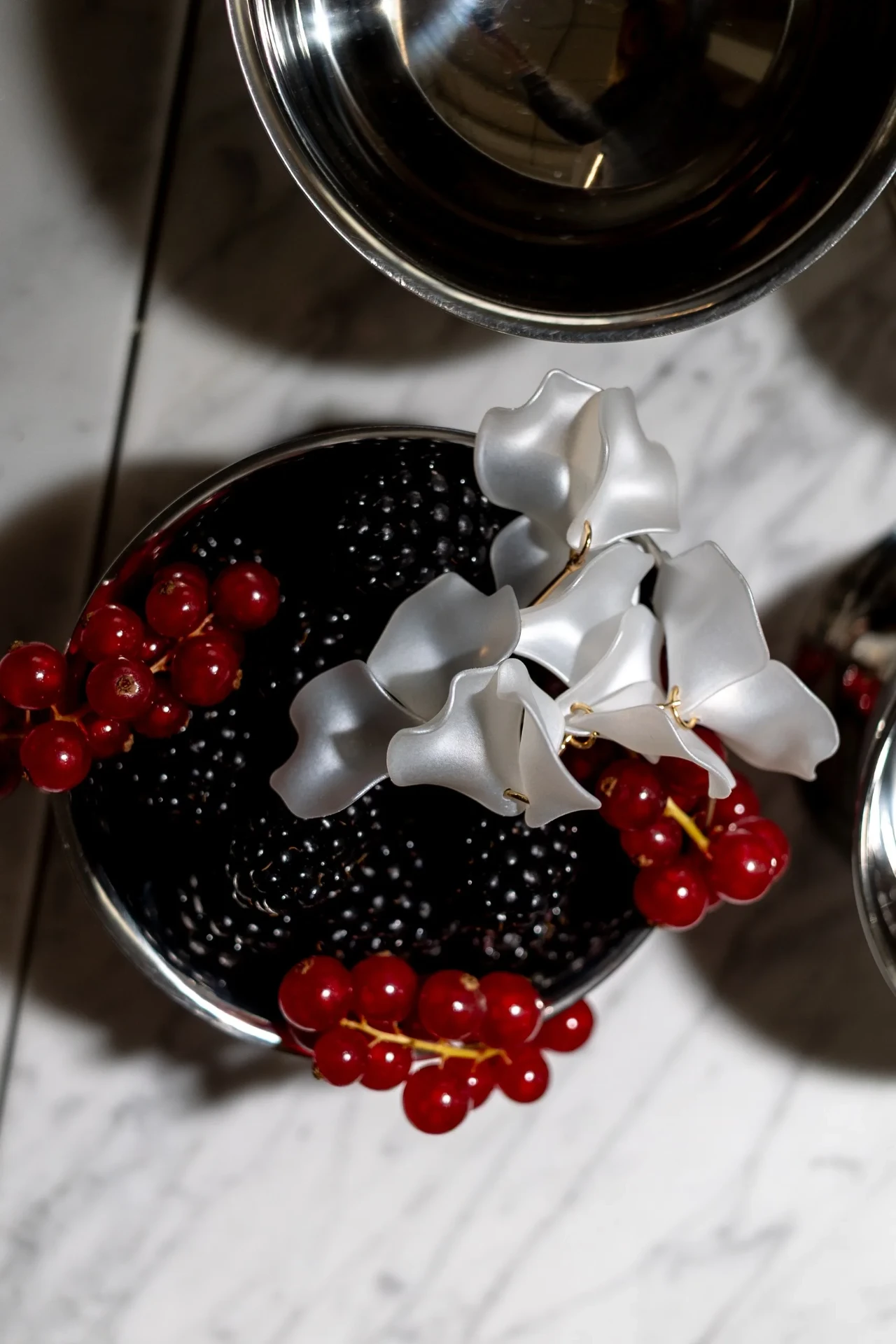Detail of red flowers and jewellery on a table