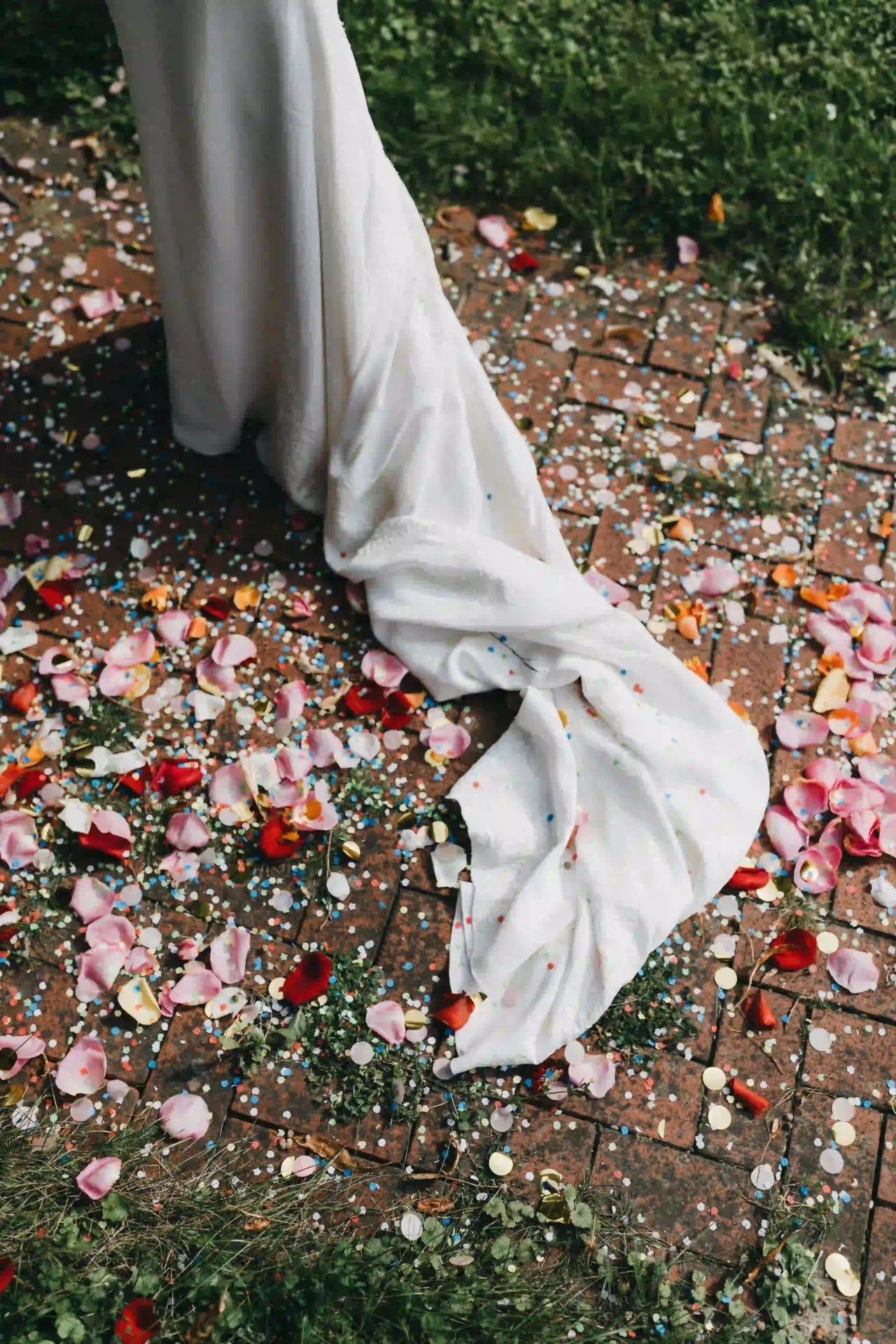 Detail of the wedding dress with confetti scattered on the ground