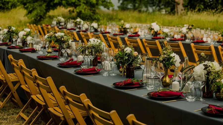 Long outdoor wedding table with yellow chairs