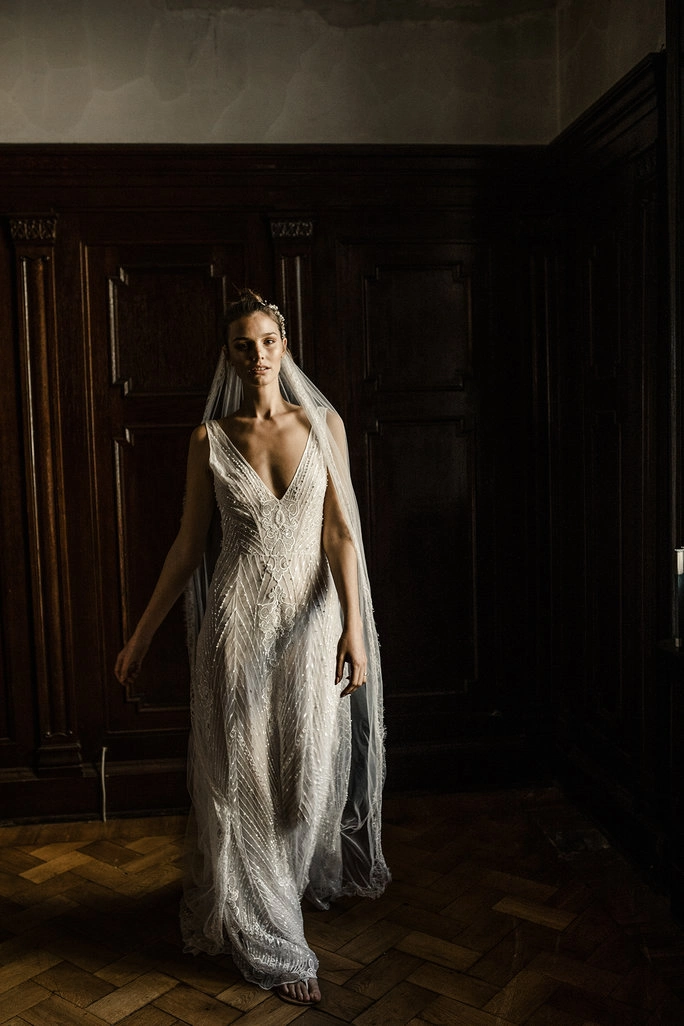 Braut im Hochzeitskleid vor einem dunklen Holzhintergrund