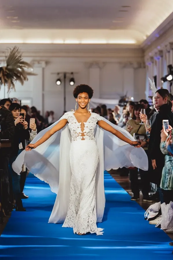 Bride in a white dress on a runway among guests