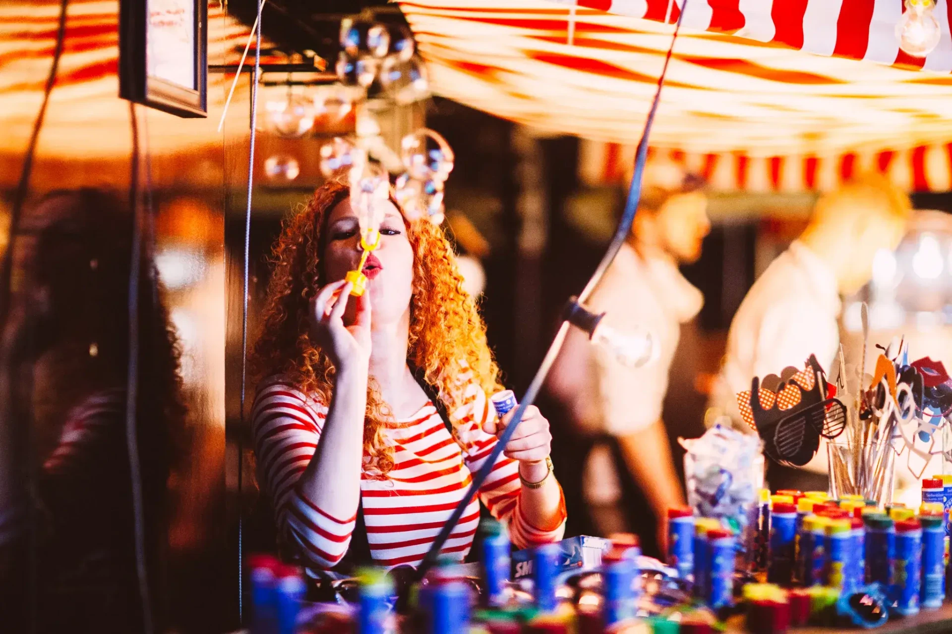 Guests celebrating at a bar with a striped awning
