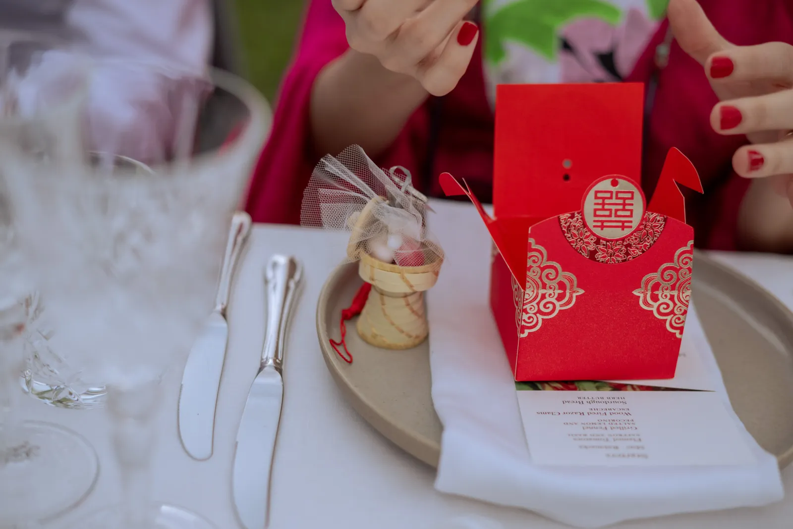 Red gift boxes and small wedding favours on a reception table