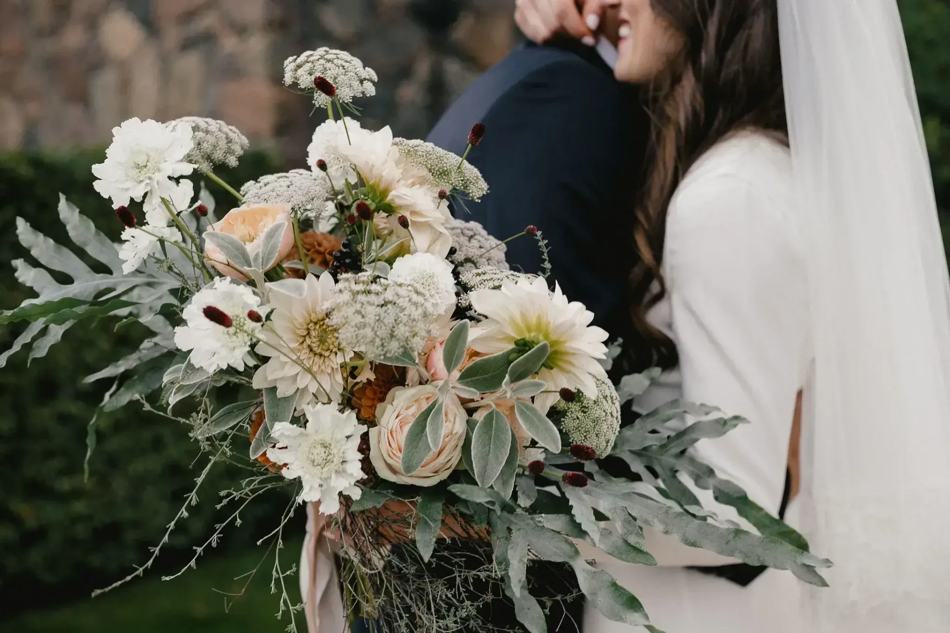 Wedding couple with a lush bouquet in a garden