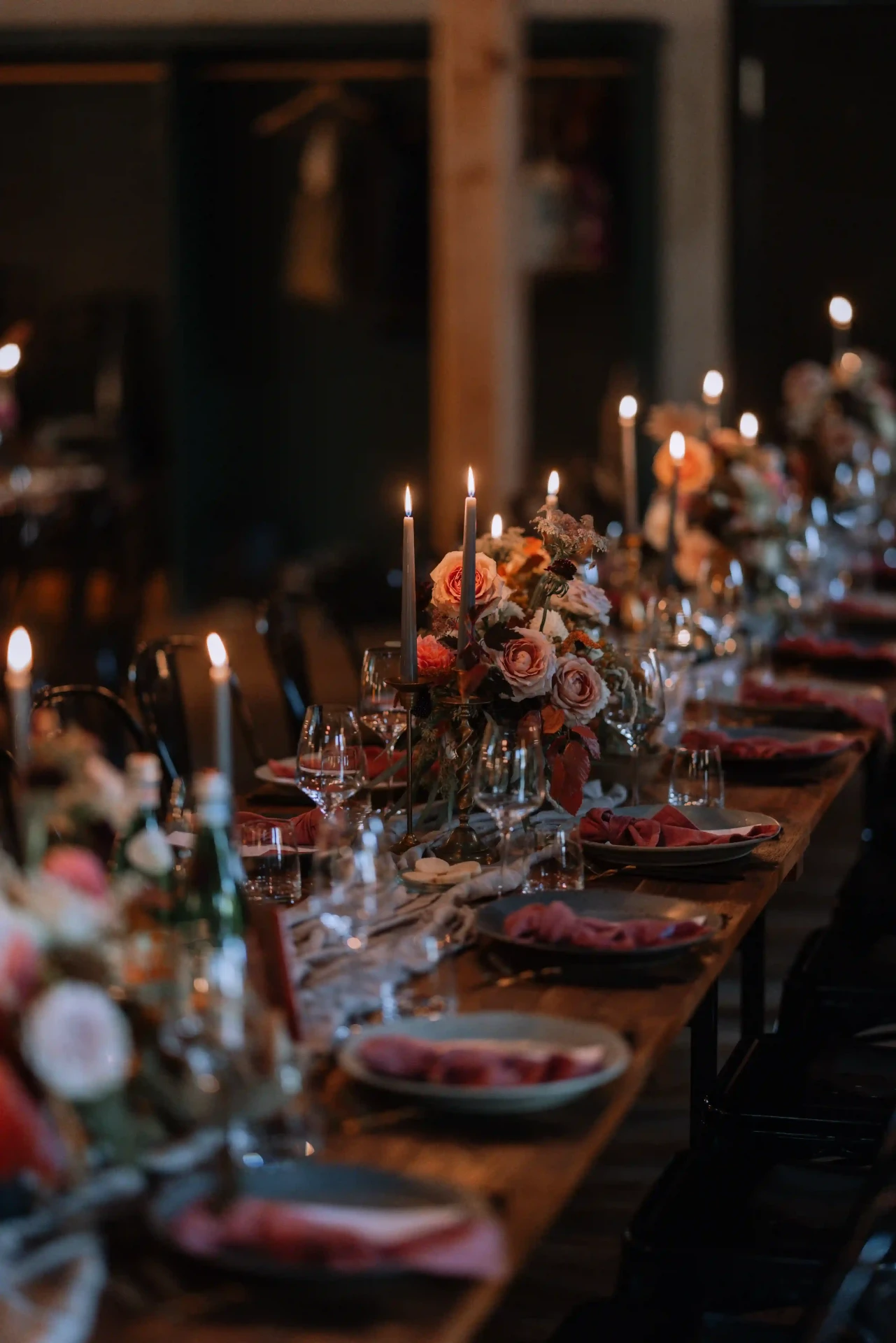 Guests seated at a long candlelit wedding table