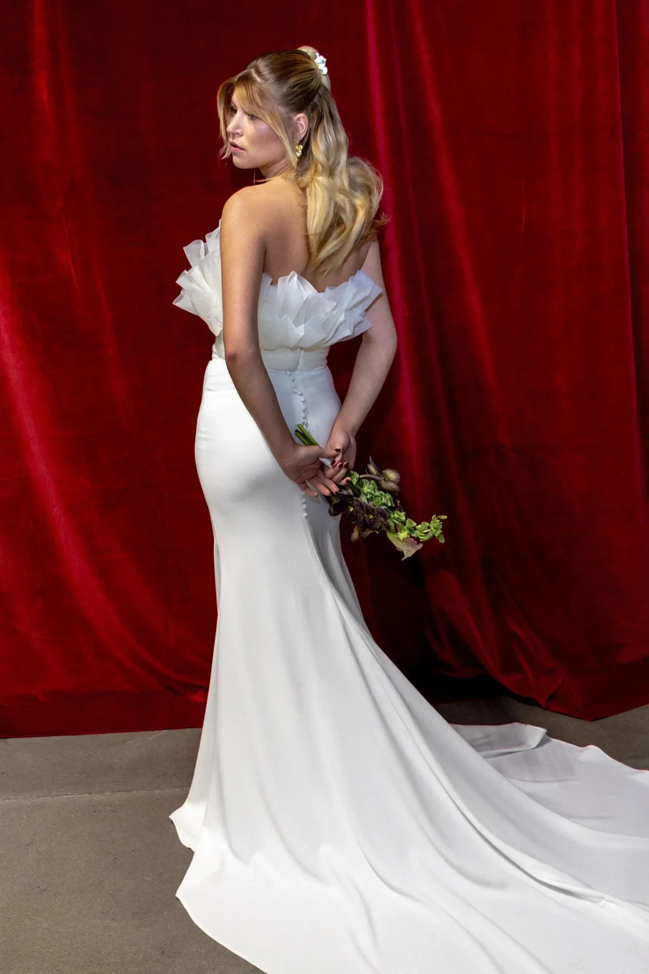 Bride in a wedding dress in front of a red backdrop