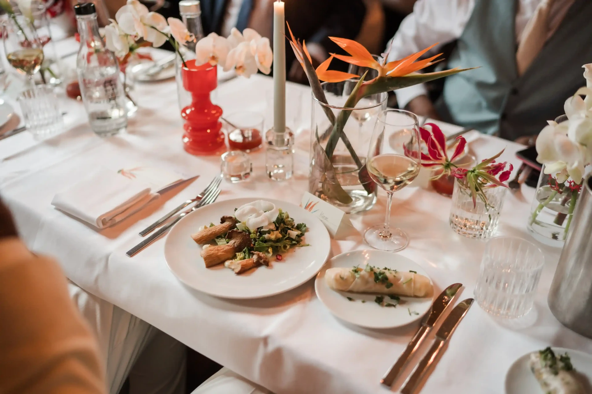 Festively set wedding table with plates, glasses and small dishes