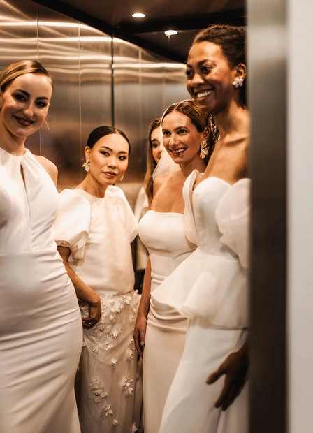 Group of guests in light-coloured outfits at an event